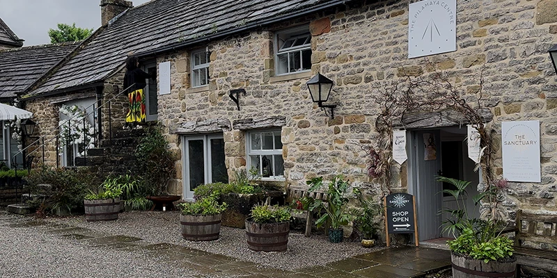 Stone cottages with flower pots and greenery in Eyam
