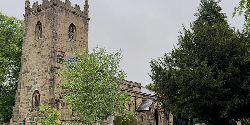 The square tower of the parish church of St. Lawrence in Eyam
