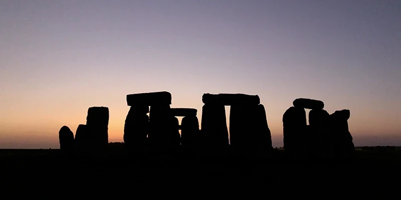 The last light of sunset behind the stones of Stonehenge
