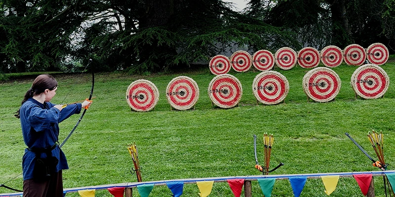 Visitors trying archery with old-fashioned bows at Warwick Castle