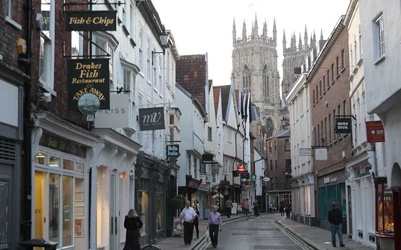 Narrow shopping street in York with the Minster beyond