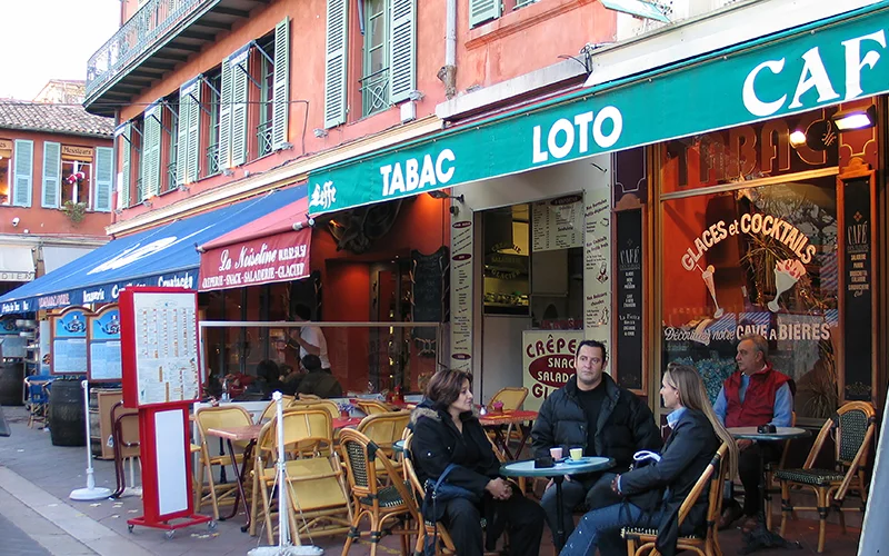 People at outdoor cafe tables on the Cours Saleya in Nice