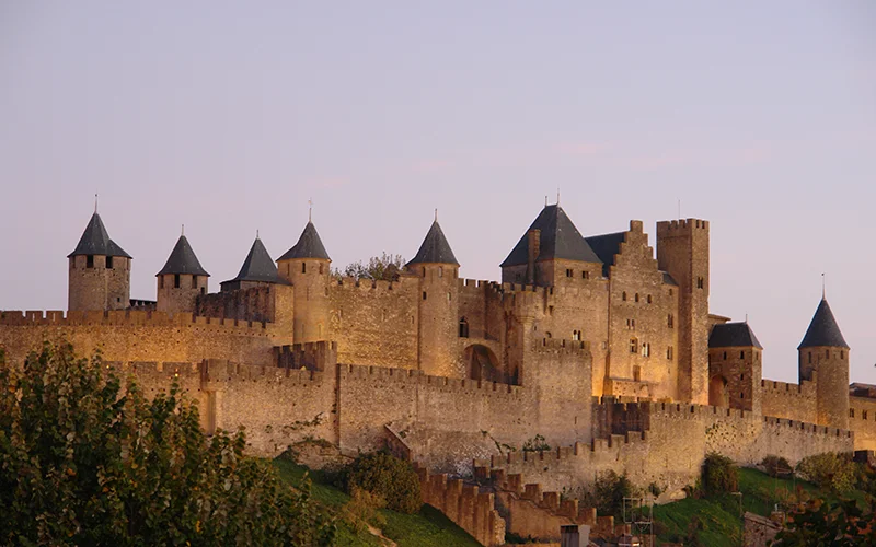 Carcassonne floodlit at dusk under a pink sky