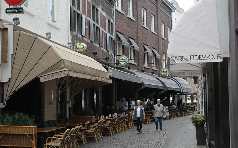 Cafe awnings and outdoor tables on a street in Maastricht
