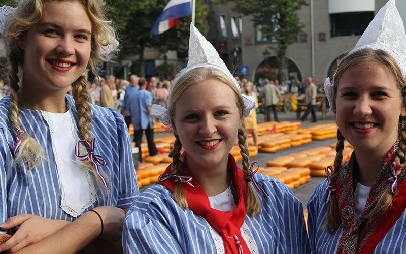 Three women in traditional Dutch costume at the Alkmaar cheese market