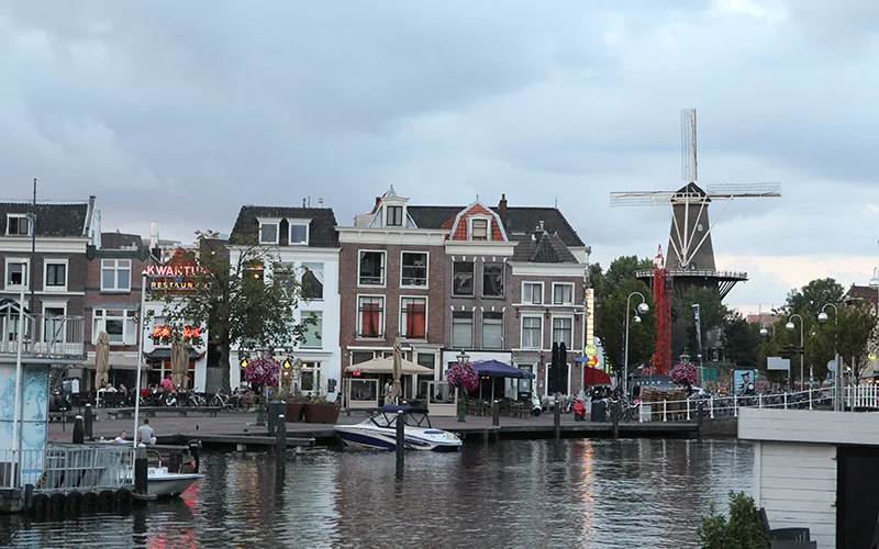 Canal in Leiden with a windmill beyond the houses