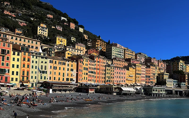 The waterfront of Camogli with tall painted houses above the beach