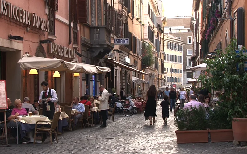 Outdoor cafe tables outside a pasticceria on a Roman street
