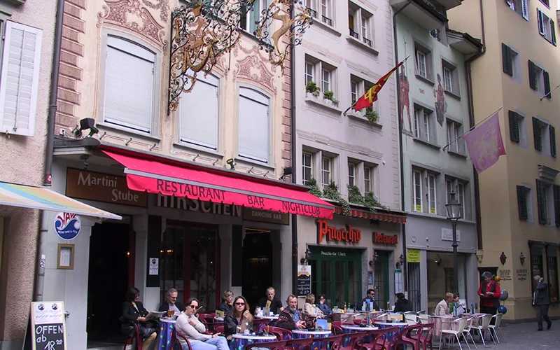 Cafe tables in a Lucerne square with painted building facades
