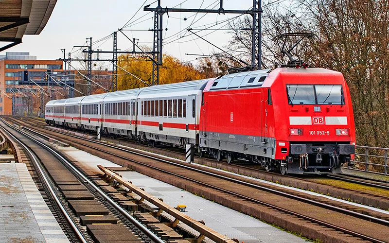 Red locomotive with intercity coaches at a station platform