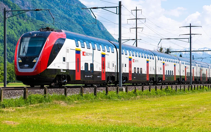 Swiss double-deck train running through a green valley