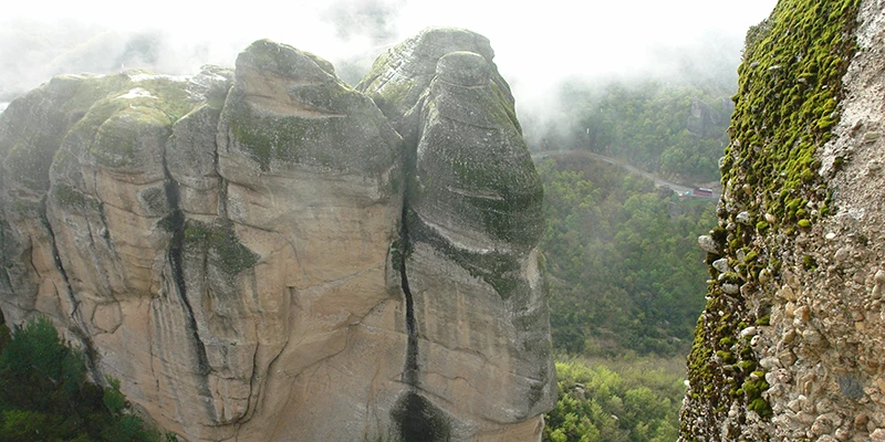 Sandstone rock pinnacles of Meteora rising above green forest