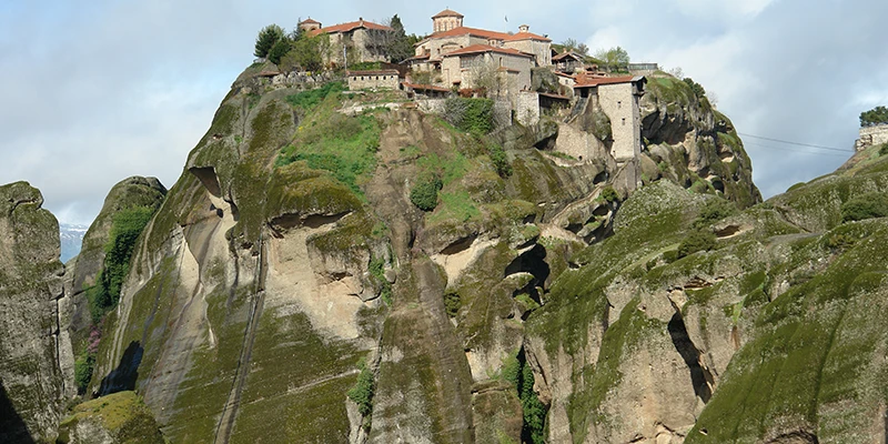 Monastery buildings clustered atop a Meteora pinnacle