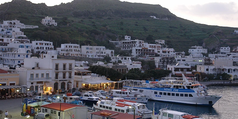 The Skala harbor with moored ferries at dusk