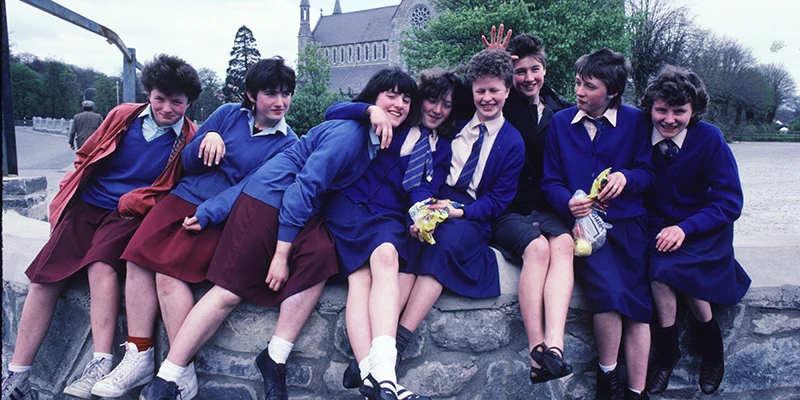Friendly schoolgirls in Ireland, dressed for school in jackets, ties and skirts
