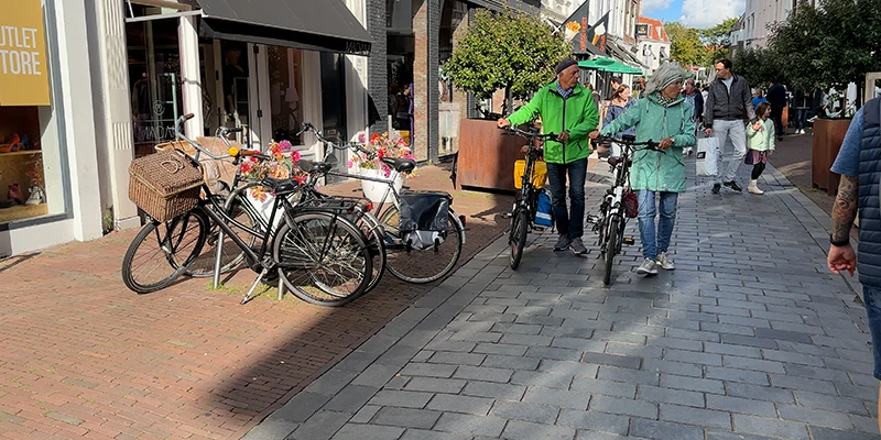 Shoppers and cyclists along a pedestrian shopping street in Middelburg