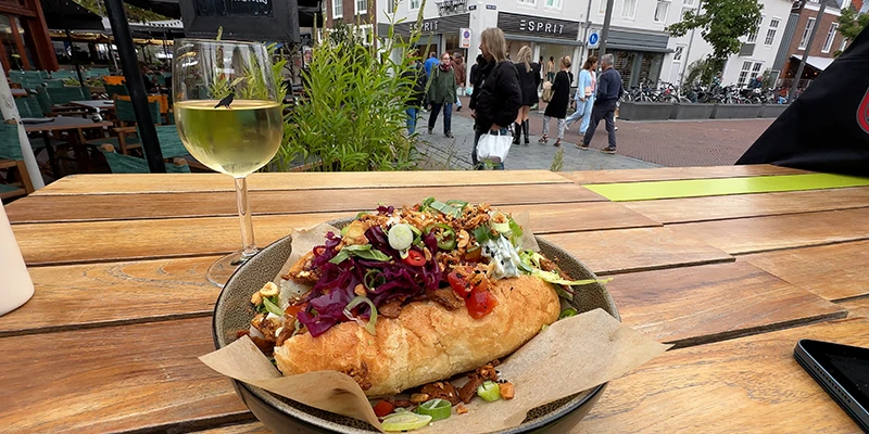 Food and a glass of wine at an outdoor café table in Middelburg